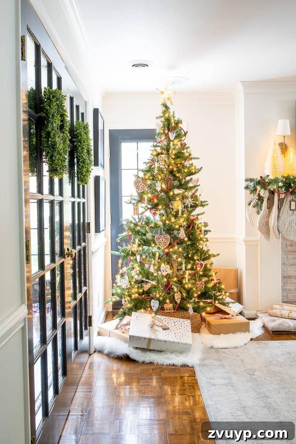 Festive Home Tour 22 Christmas decor ideas: A beautifully adorned Swedish Christmas tree stands proudly next to elegant French doors, creating a picturesque and inviting holiday scene in the living room.