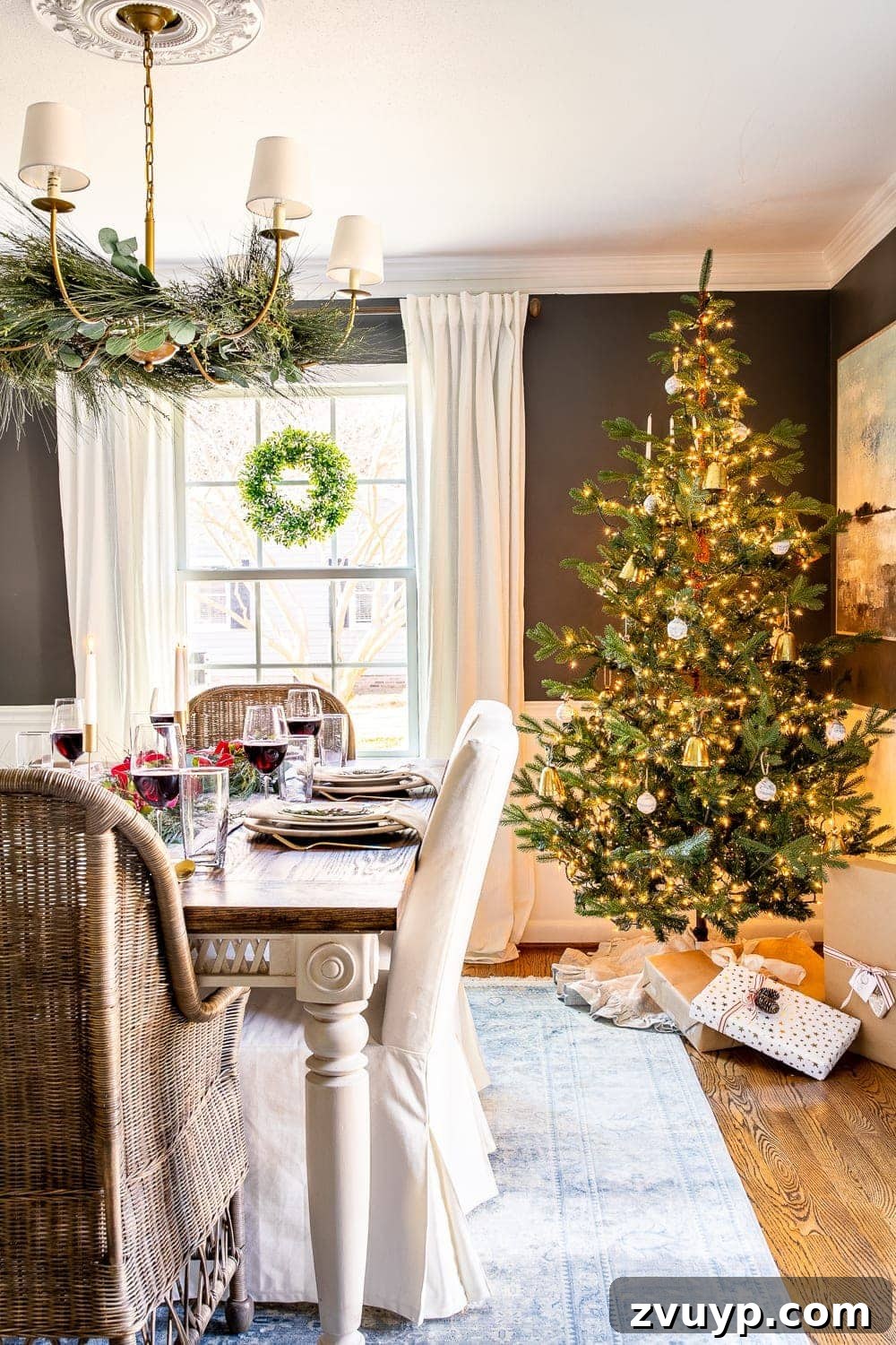 Festive Home Tour 7 Christmas decorating ideas: Dining room with a festive Christmas tree, elegant garland draped over the chandelier, and wreaths adorning the windows, creating a magical holiday atmosphere.