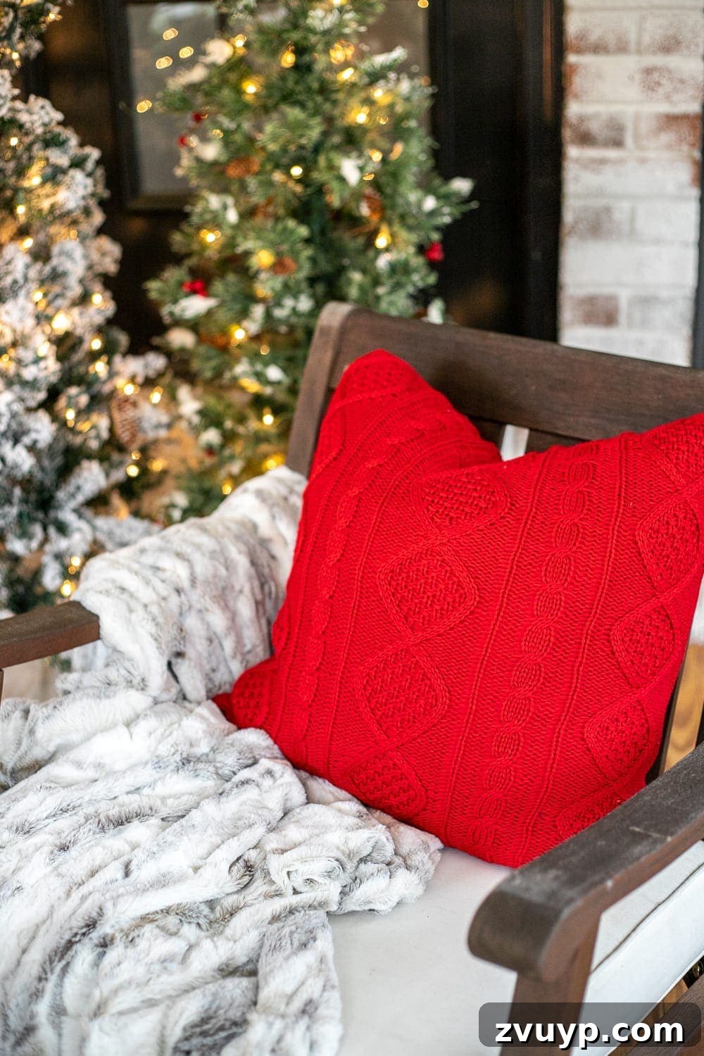 Warm Yuletide Veranda 7 Close-up of a festive Christmas throw pillow paired with a luxurious faux fur blanket