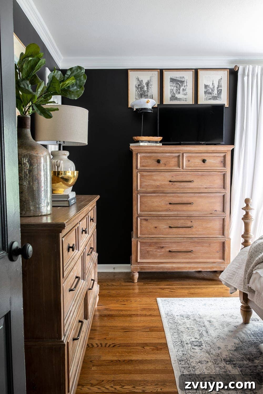 A Masterpiece in Mood: Our Modern Vintage Master Bedroom Unveiled 9 Moody modern vintage master bedroom featuring a dresser with a TV subtly camouflaged against black paint, adorned with personal decor.