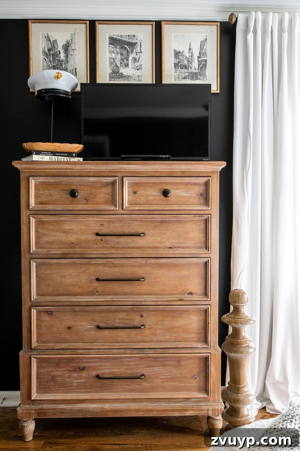 A Masterpiece in Mood: Our Modern Vintage Master Bedroom Unveiled 10 Bedroom TV discreetly placed on a dresser top, surrounded by personalized art and a sentimental Marine Corps cover, against dark black walls.