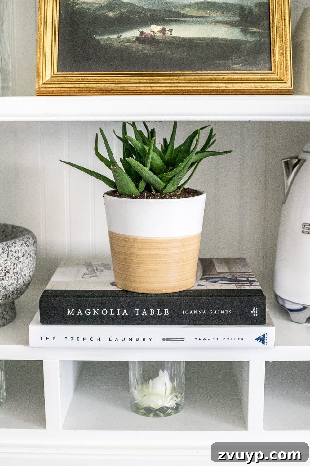 Simple Ways to Style Your Shelves 12 A styled shelf featuring books, decorative items, and a plant, creating a balanced and aesthetic display.
