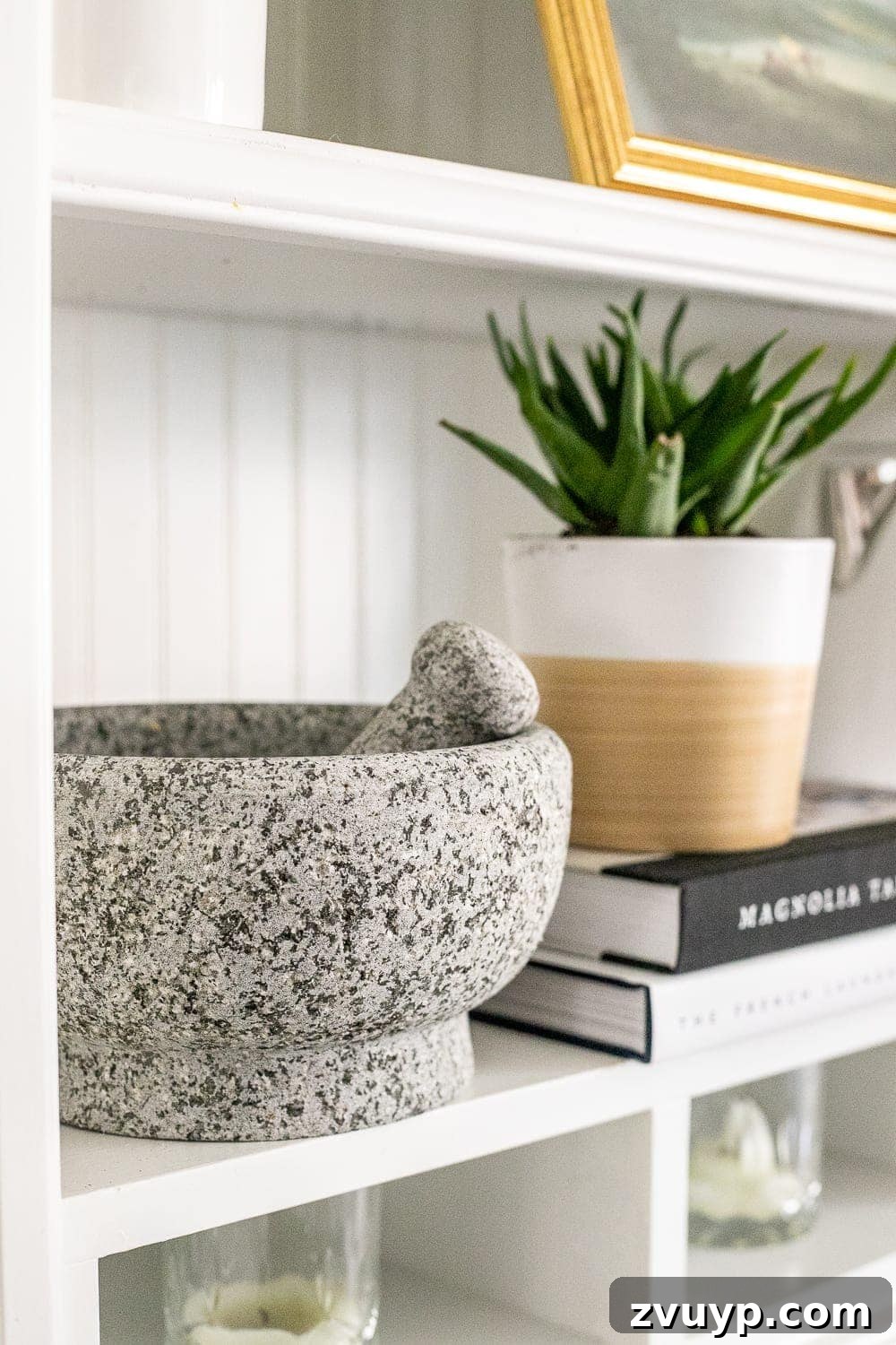 Simple Ways to Style Your Shelves 14 A concrete mortar and pestle displayed on a shelf, showcasing a blend of functional and decorative items.