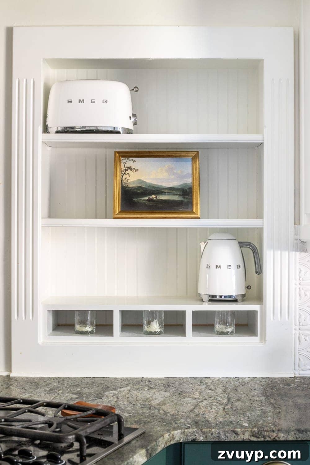 Simple Ways to Style Your Shelves 6 Two white Smeg appliances, a kettle and a toaster, are spaced out on opposite sides of the shelves for balance.