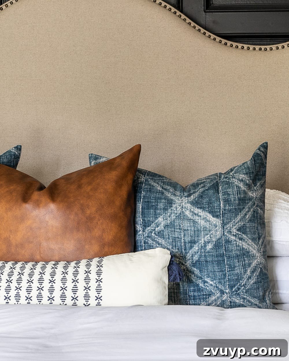 Clever Hacks for a Cloud-Like Bed on a Budget 3 Throw pillows arranged artfully on a bed, showcasing the fluffy effect of larger inserts.