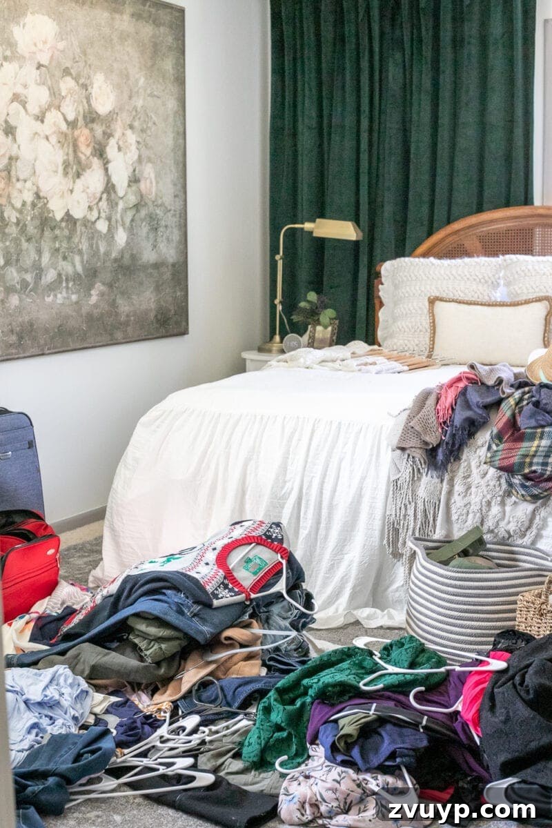 Your Definitive Guide to a Decluttered Wardrobe 7 Clothes piled on a bed during a closet cleanout, showing the messy reality of decluttering.