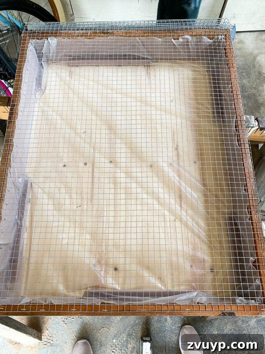 Craft a Vertical Garden from Reclaimed Wood 14 Stapling steel hardware cloth to the wooden frame of the vertical planter, creating the front mesh for plant placement.