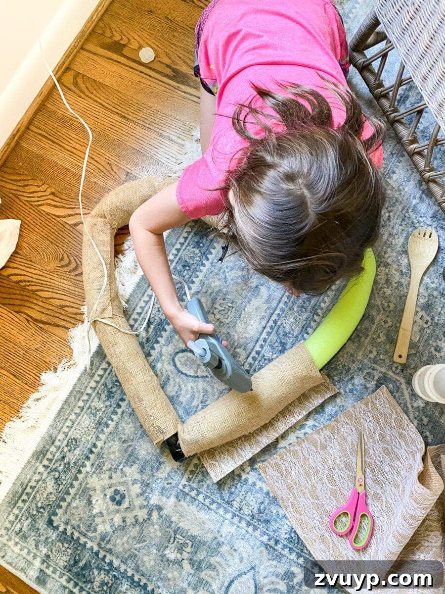 Transforming a Pool Noodle into a Unique Wreath 7 Wrapping wreath with scrap burlap fabric