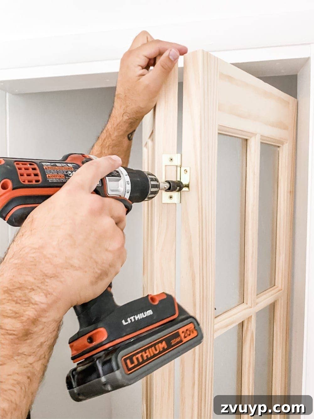 Close-up of a bi-fold door showing the hinges being unscrewed in the middle
