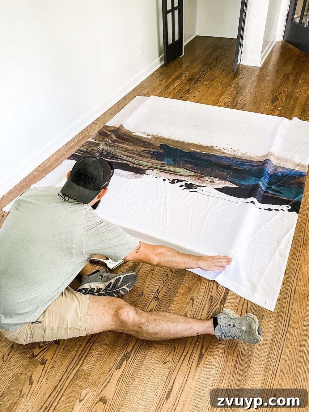 Transform a Shower Curtain into Statement Wall Art 8 Shower curtain being aligned and temporarily stapled to the top edge of the DIY canvas frame.