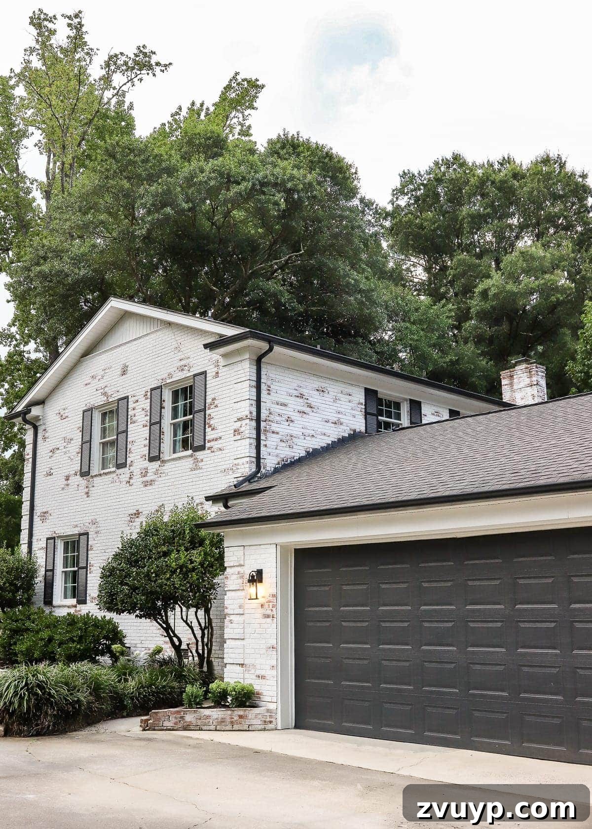 Revamping Our Garage Exterior with Bright New Lighting 4 Transformed garage exterior showcasing updated paint, landscaping, and lighting.