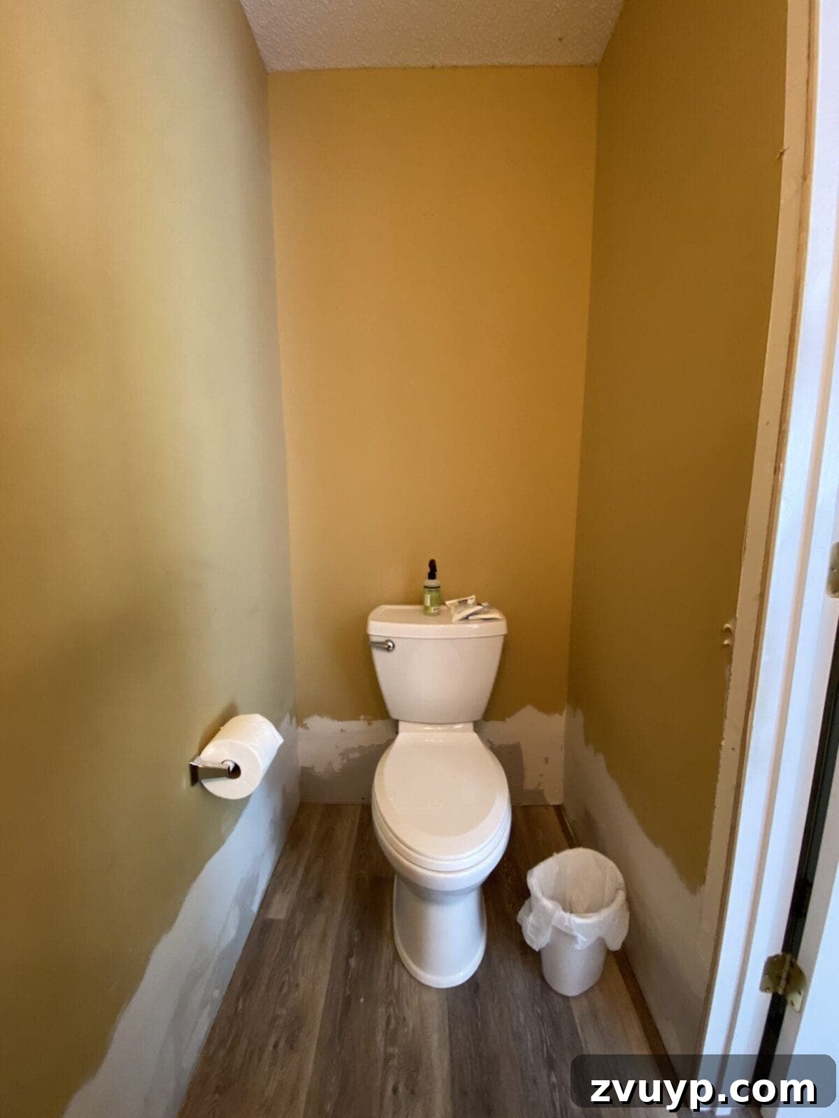 Golden State Powder Room Serenity 11 Before photo of a gold bathroom, showing plain walls above the toilet