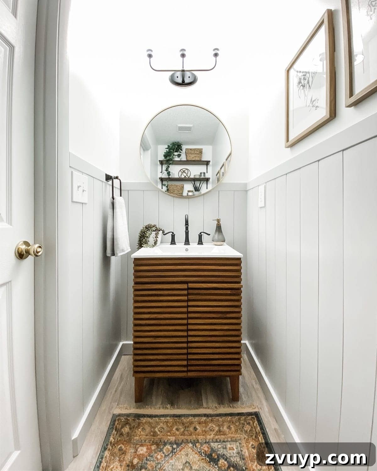 Golden State Powder Room Serenity 5 After photo of a small powder room featuring vertical shiplap, a Mid Century Modern style vanity, and a round mirror