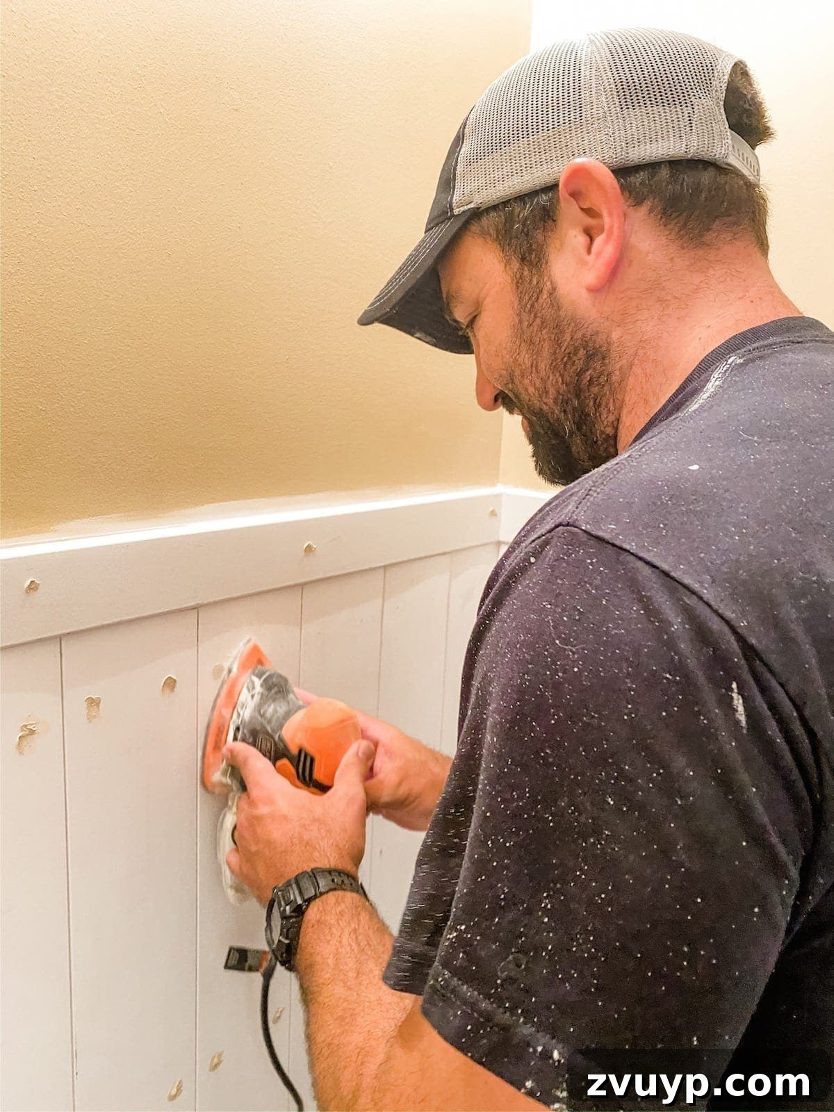 Effortless Bathroom Makeover: DIY Vertical Shiplap Wainscoting 15 Sanding wood filler on vertical shiplap planks for a smooth finish.