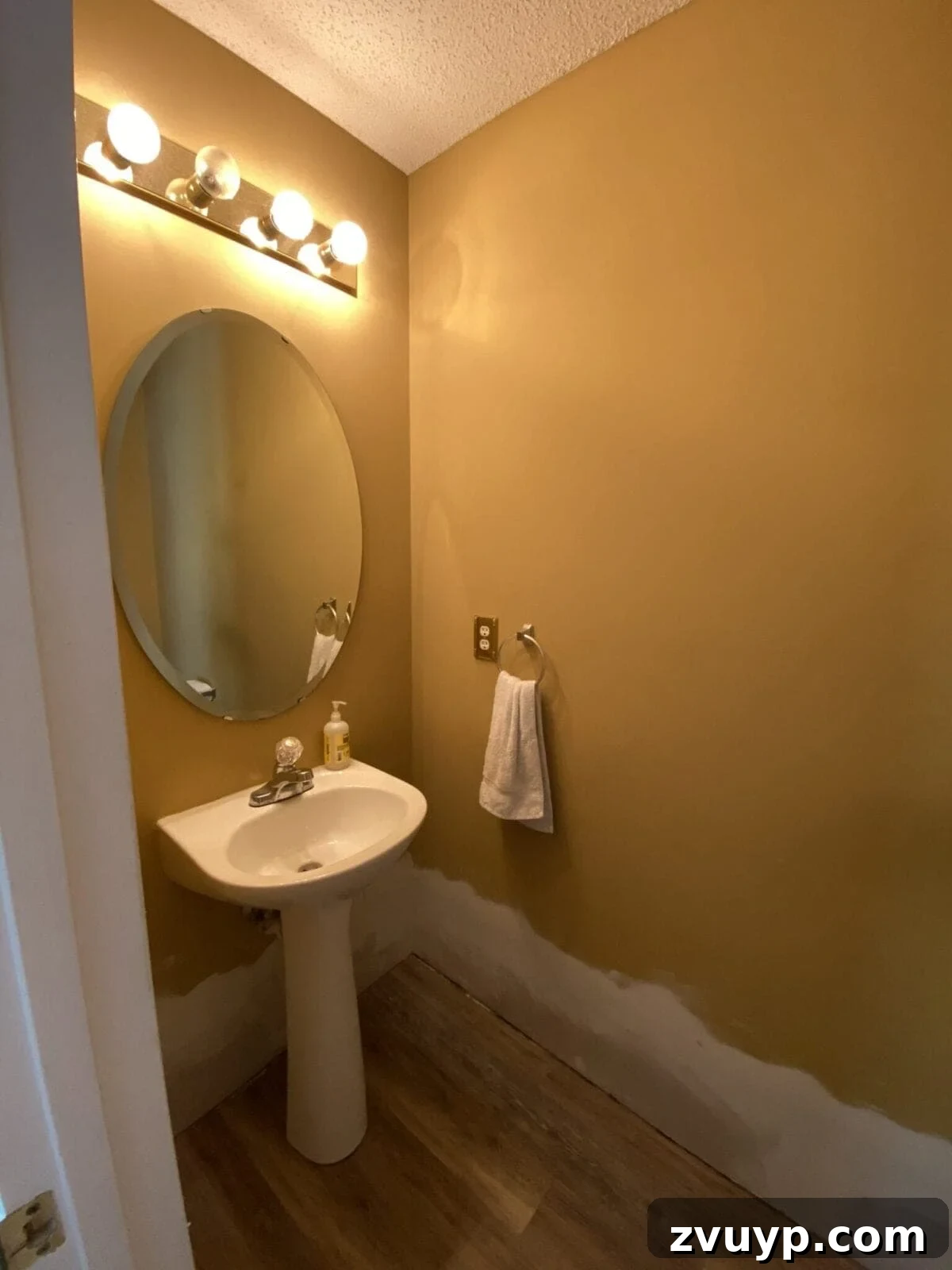 Effortless Bathroom Makeover: DIY Vertical Shiplap Wainscoting 3 Before shot of a powder room with outdated gold walls, highlighting the need for a modern update.