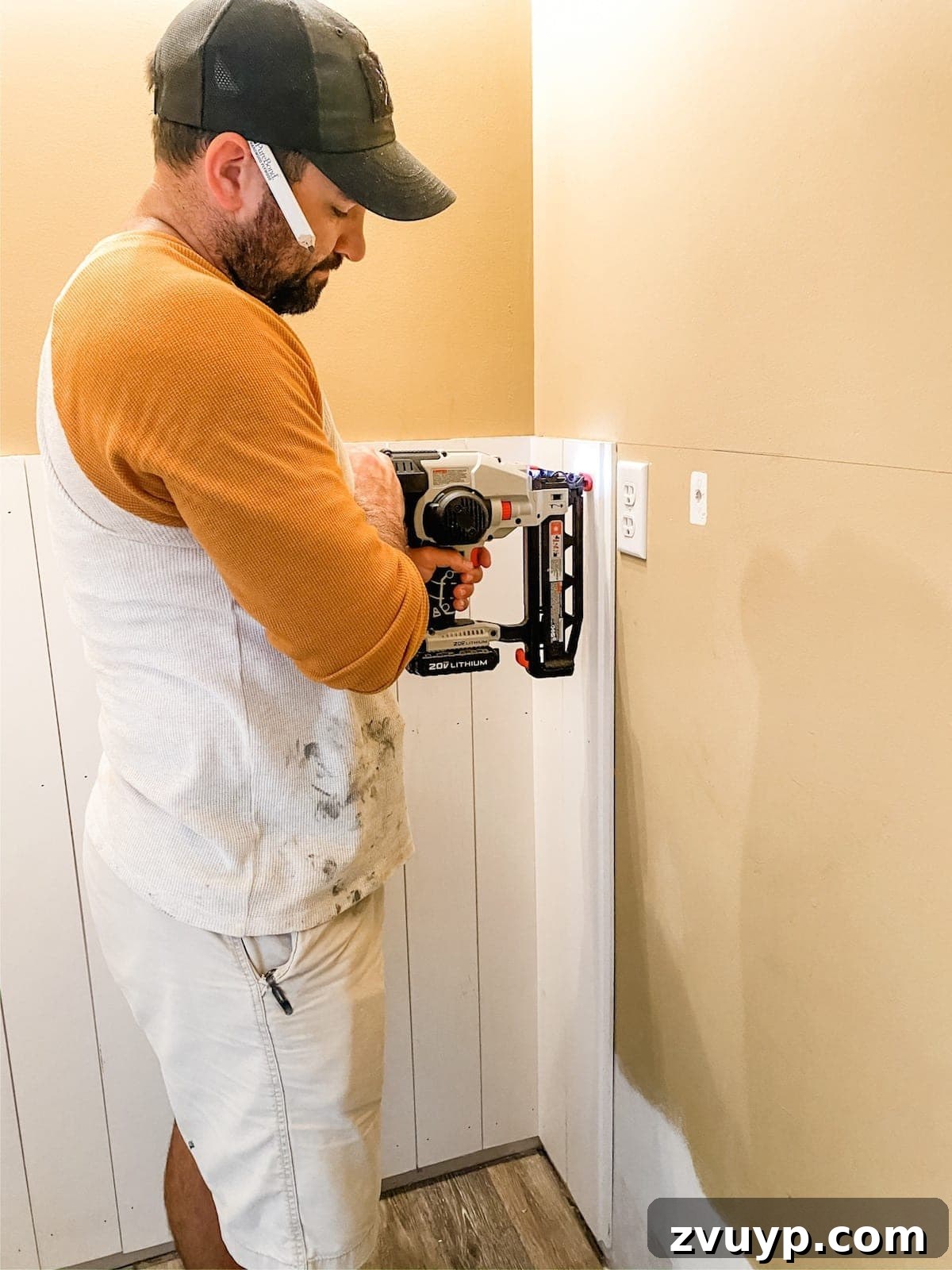Effortless Bathroom Makeover: DIY Vertical Shiplap Wainscoting 6 Attaching vertical shiplap boards to the wall using a finish nailer.