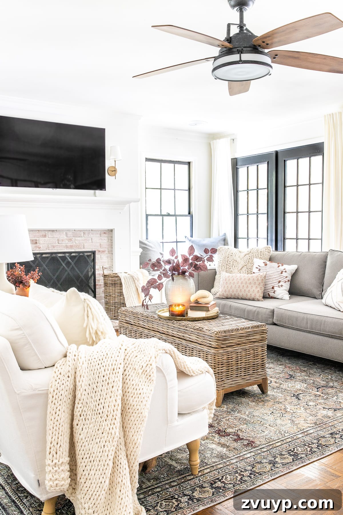 An Earthy Fall Living Room and My Go-To Budget Fall Decor Capsule 3 A tastefully decorated fall living room featuring a vintage-style rug, autumn leaves in a vase, and a warm, inviting atmosphere.