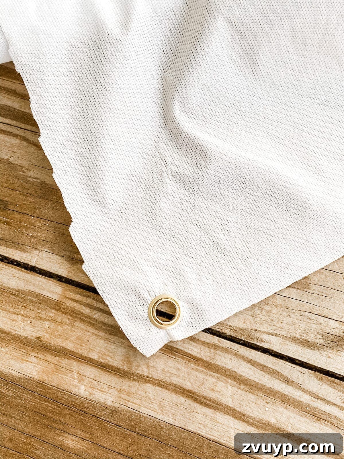 DIY Outdoor Movie Screen Step 3 Installing eyelets into the corners of a shower curtain liner for the movie screen