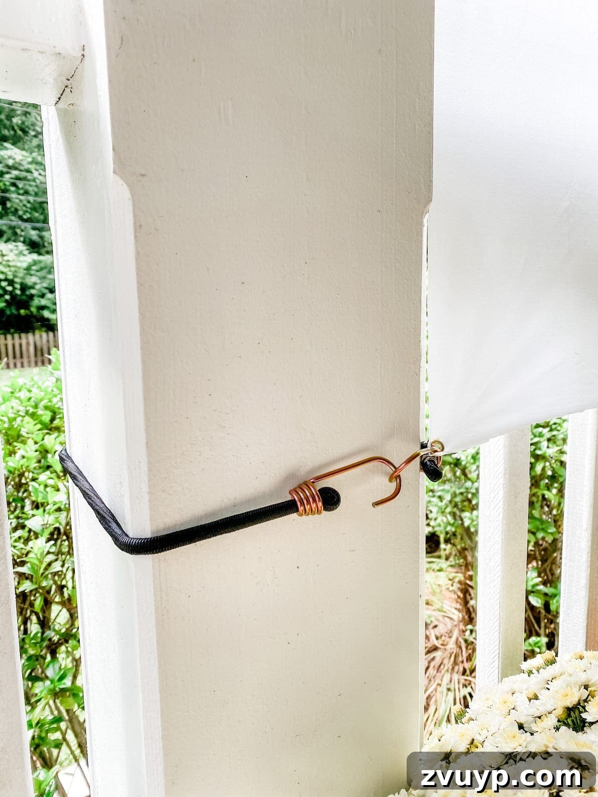 DIY Outdoor Movie Screen Mounted Hanging the DIY outdoor movie screen with bungee cords on porch posts