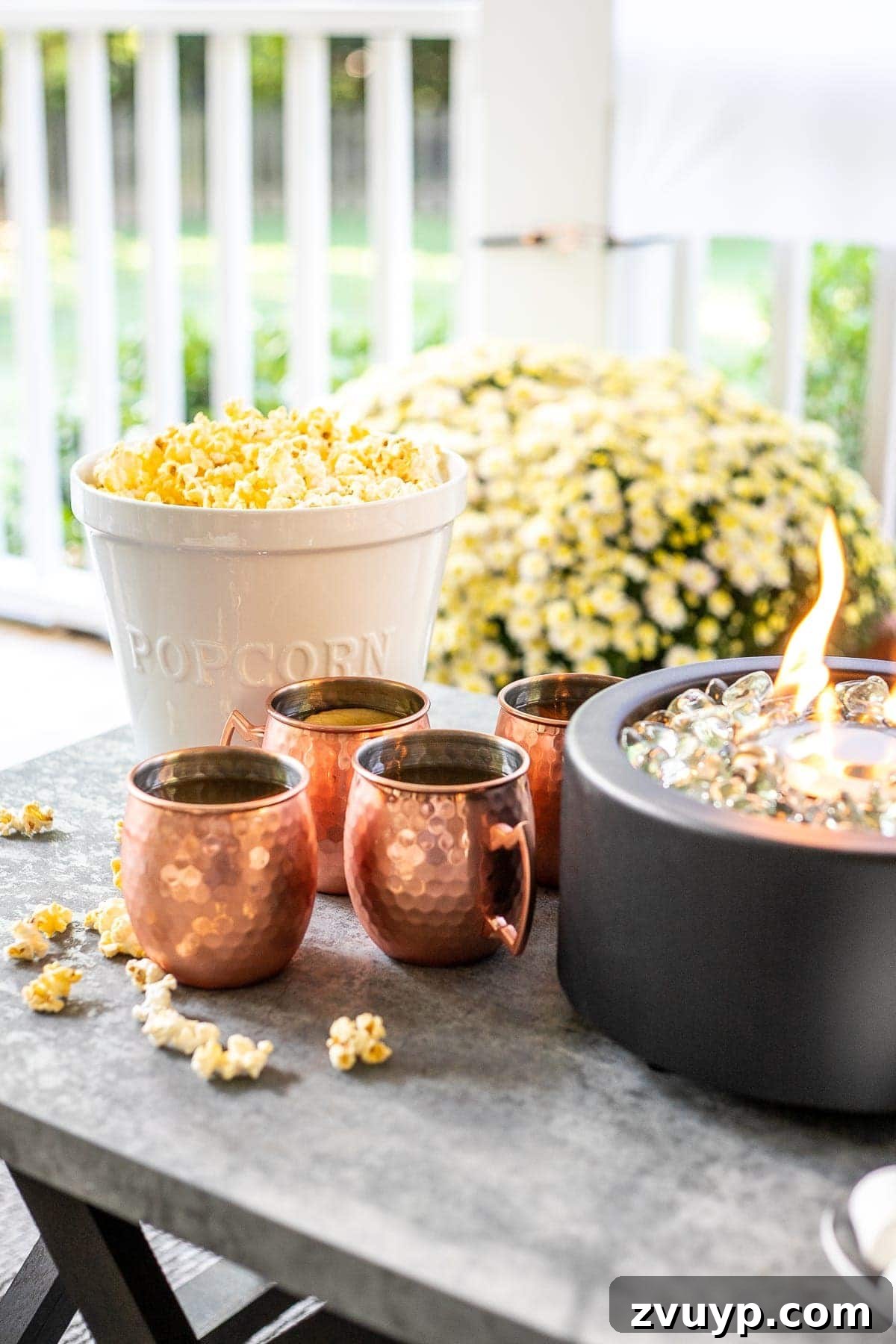 S'mores Table Delights Close-up of copper mugs, popcorn bowl, and fire bowl on s'mores table