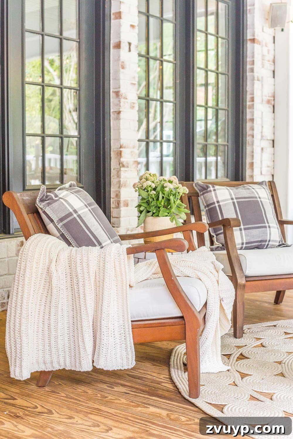 Your Guide to a Serene Outdoor Retreat: 4 Key Elements 8 Inviting back porch decorated for fall with comfortable outdoor textiles and festive pumpkins.