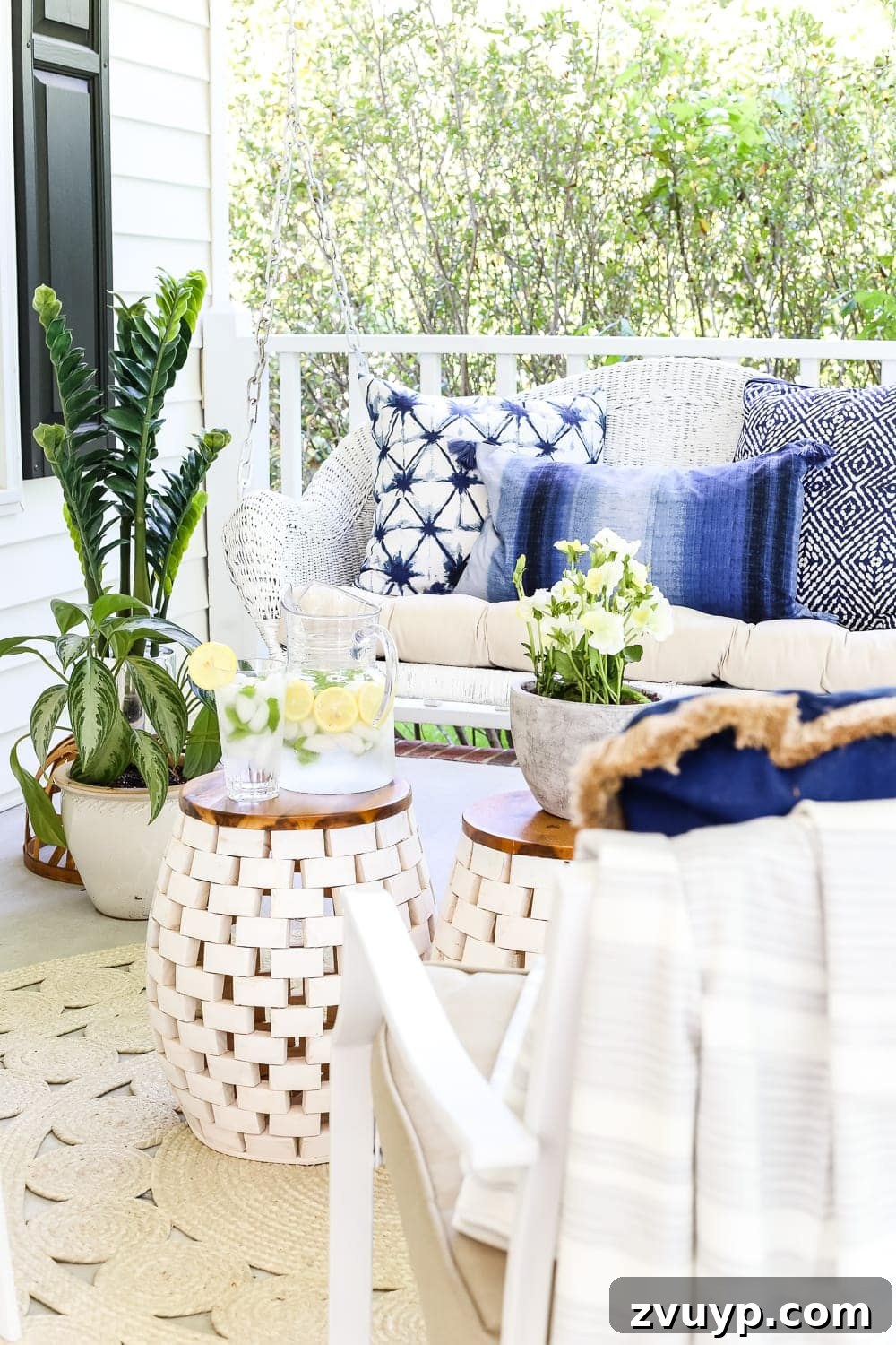 Your Guide to a Serene Outdoor Retreat: 4 Key Elements 9 Beautifully decorated front porch for summer with colorful flowers in planters and a welcoming arrangement.