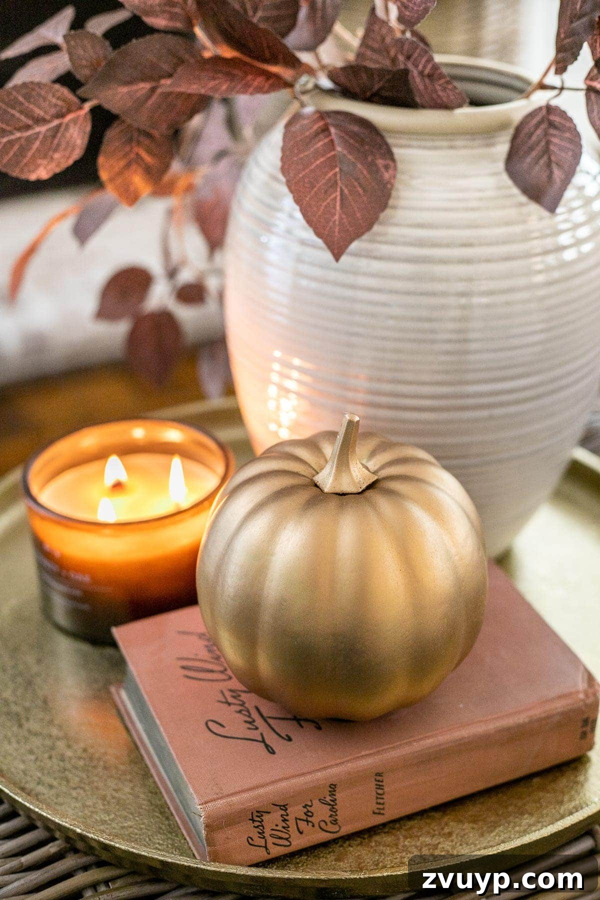 fall decor on a tray with vase of leaves, candle, and pumpkin