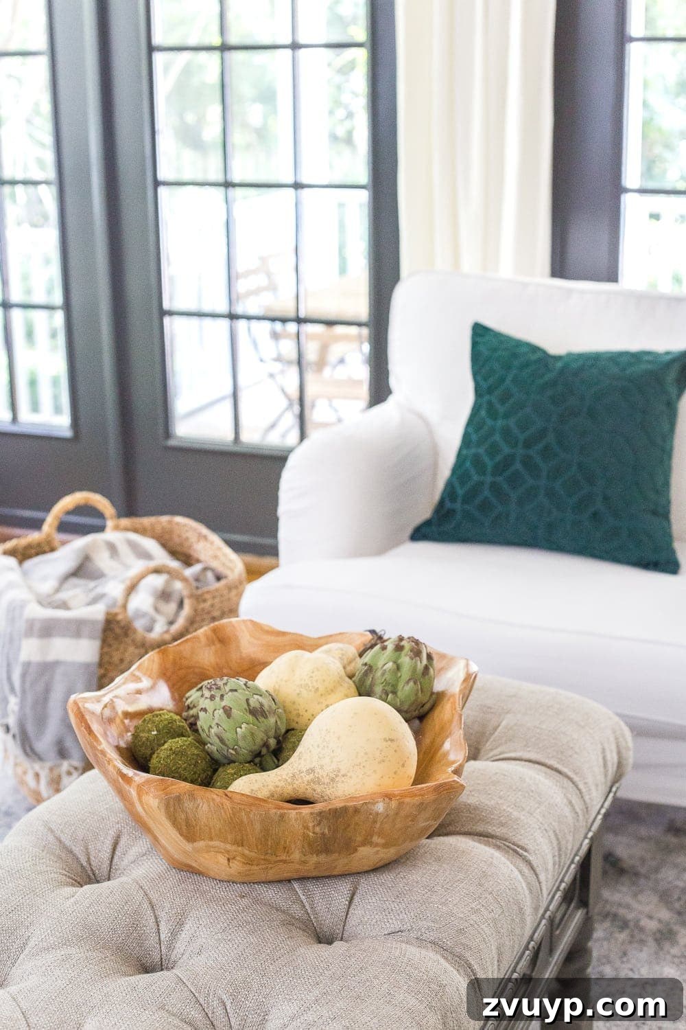 wooden bowl of gourds and artichokes on a living room coffee table