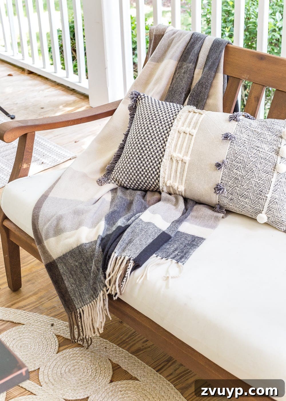 plaid throw blanket and pillow on outdoor bench