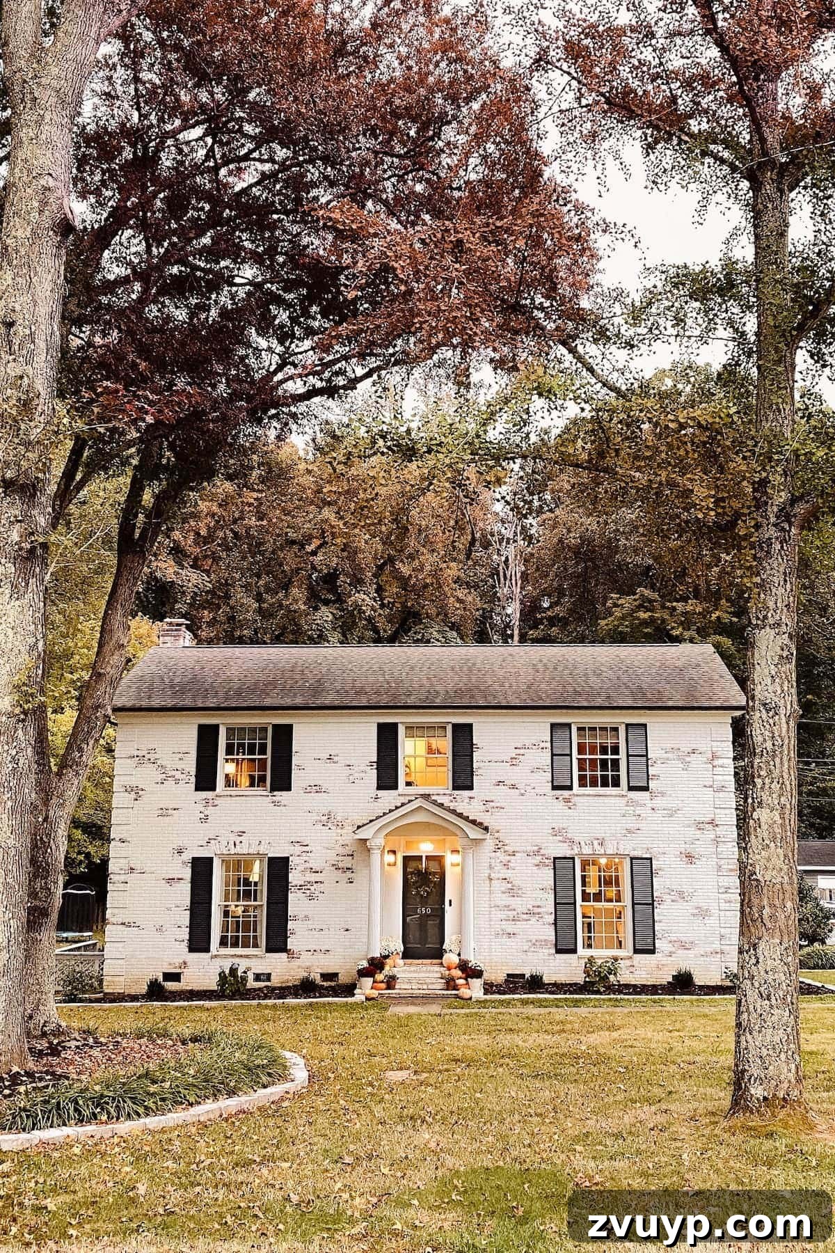 Autumn's Painted Porch 5 limewashed brick colonial house decorated for fall with pumpkins and mums