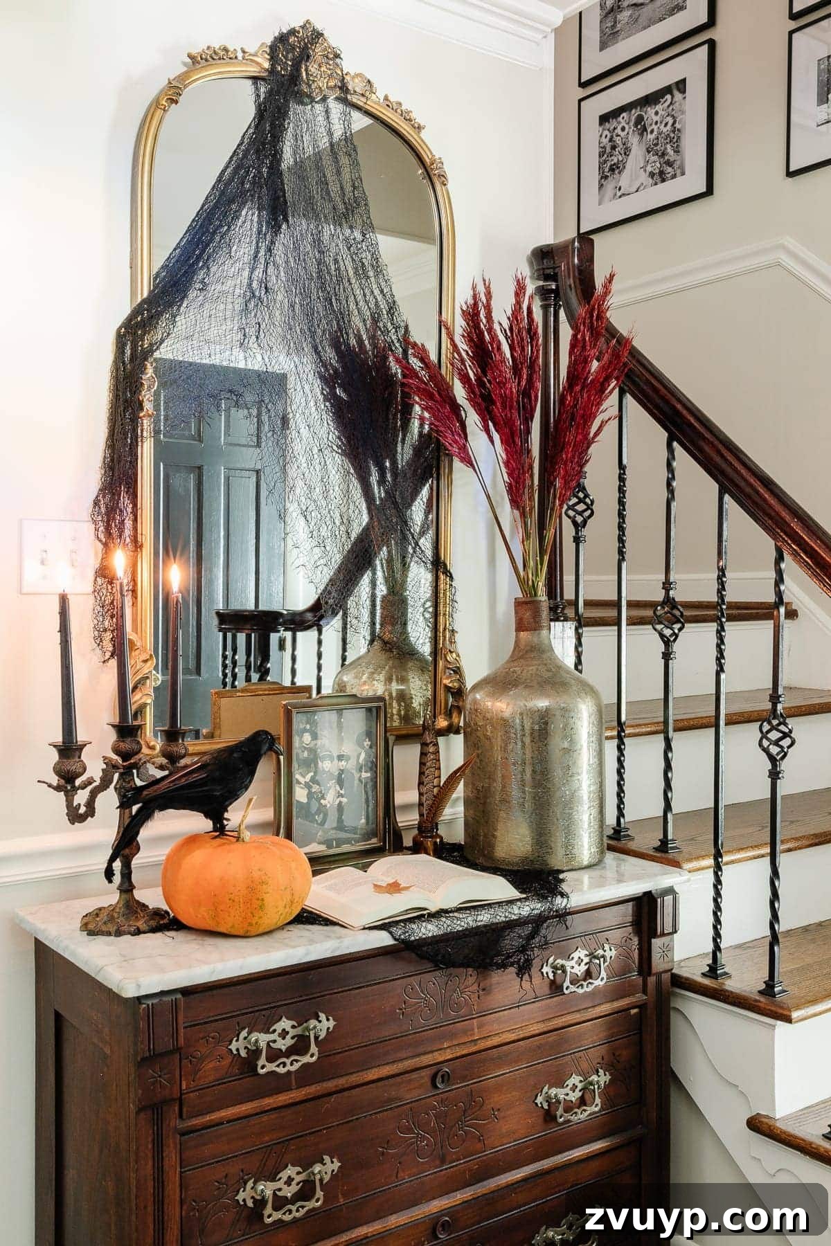 Conjuring Classic Chills: 10 Vintage Halloween Prints for Your Entryway 15 A beautifully decorated vintage Halloween entryway featuring framed antique art, pumpkins, and a warm, inviting glow.