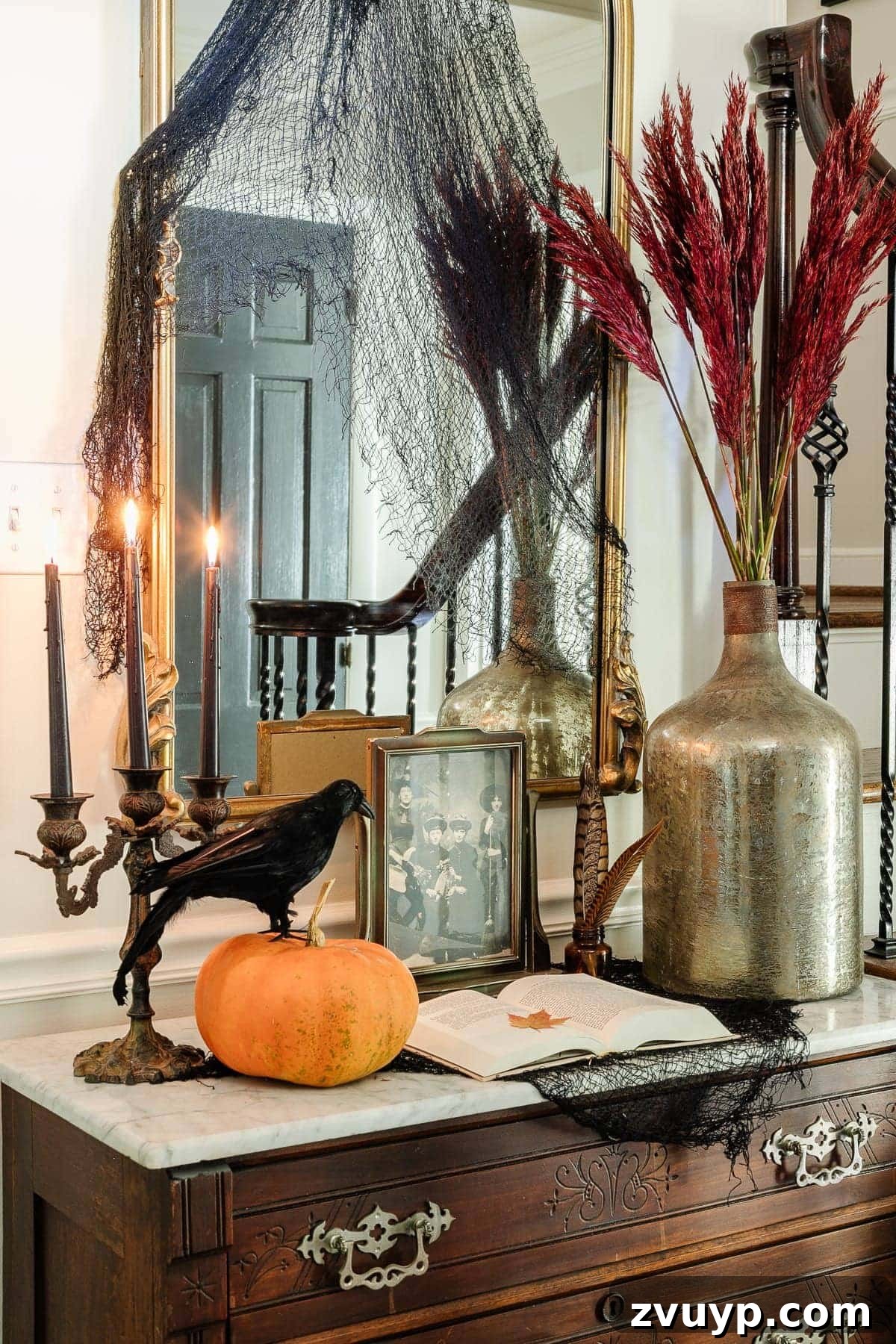 Conjuring Classic Chills: 10 Vintage Halloween Prints for Your Entryway 3 Close-up of vintage Halloween art prints displayed in an entryway, featuring a framed antique portrait and a decorative pumpkin.