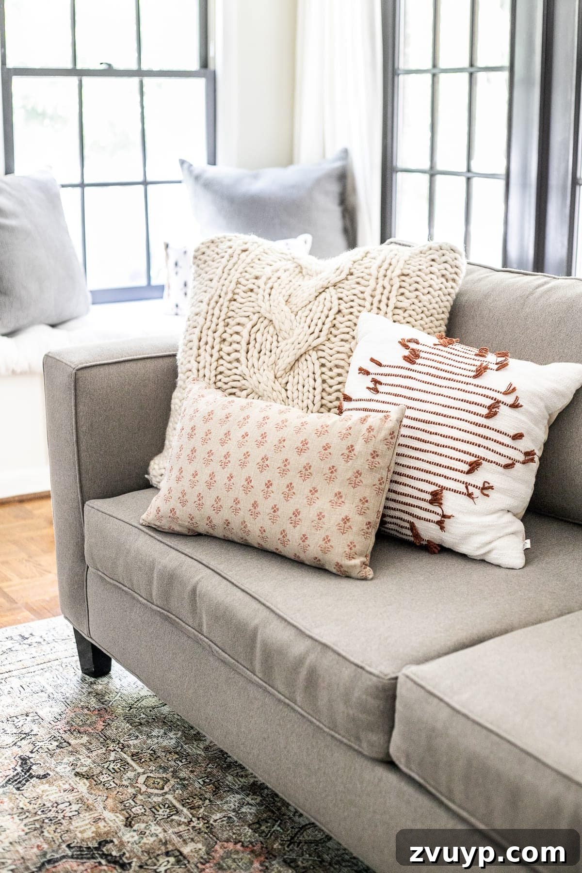 Effortless Throw Pillow Styling 5 Cozy fall themed throw pillows arranged on a sofa, featuring warm textures and subtle patterns
