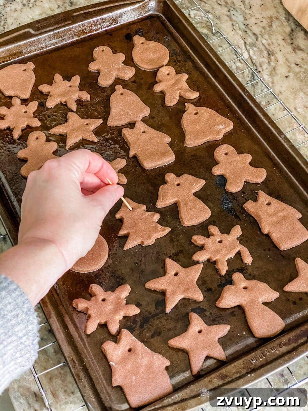 Craft Your Own Cinnamon Salt Dough Decorations 11 Using a toothpick to poke holes in the top of each cinnamon salt dough ornament for hanging after baking.