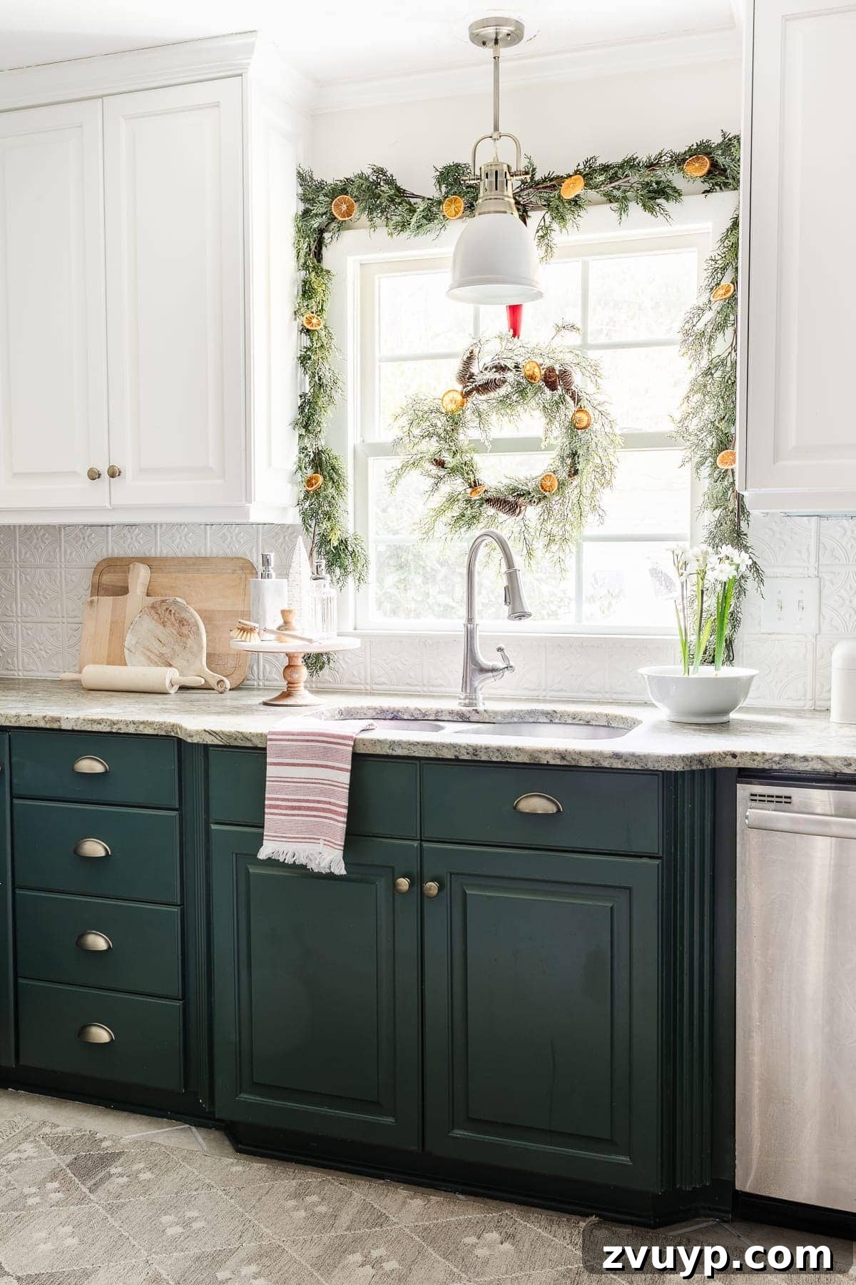 Christmas kitchen window decorated with garland and wreath with dried citrus
