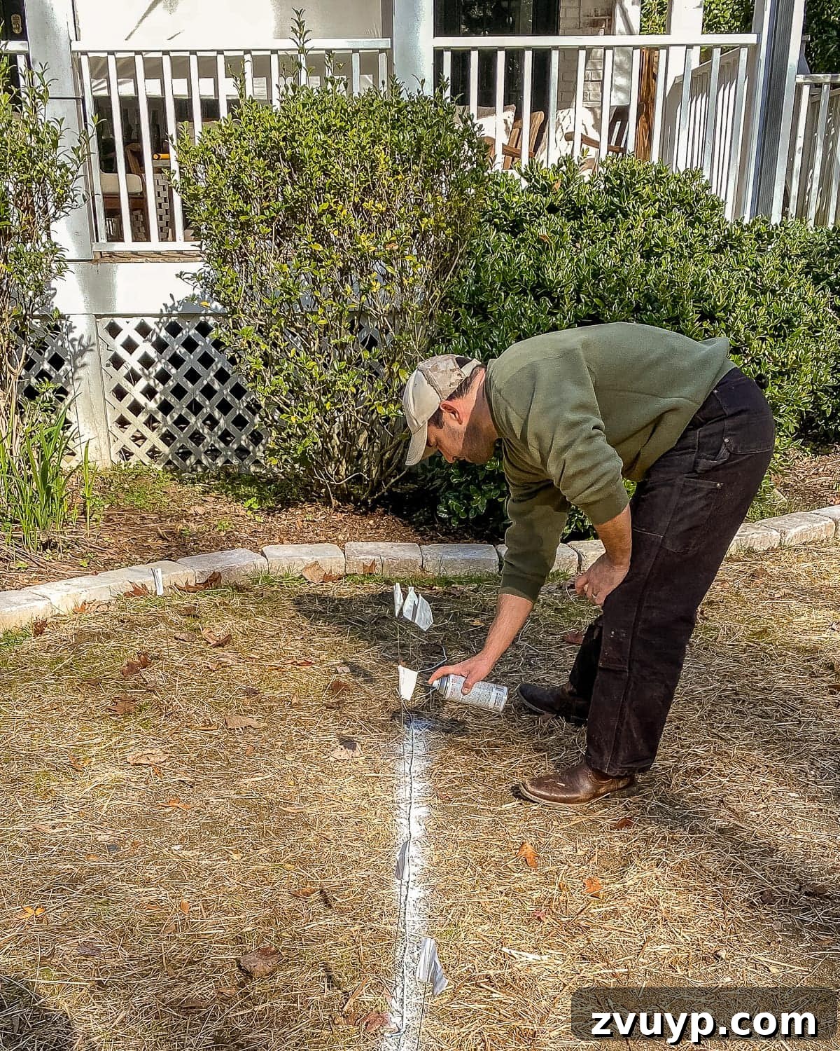 Weekend Wonder: DIY Pea Gravel Fire Pit 12 Spray painting the marked layout for a DIY fire pit patio before ground excavation.
