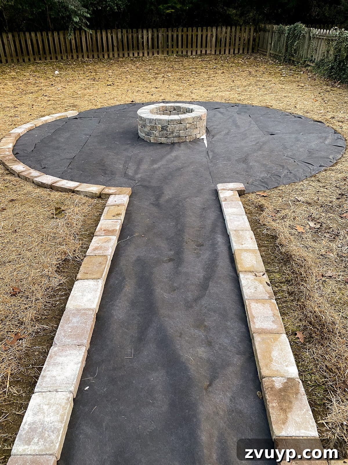 Weekend Wonder: DIY Pea Gravel Fire Pit 17 Placing edging stones around the landscape fabric perimeter of the fire pit patio.