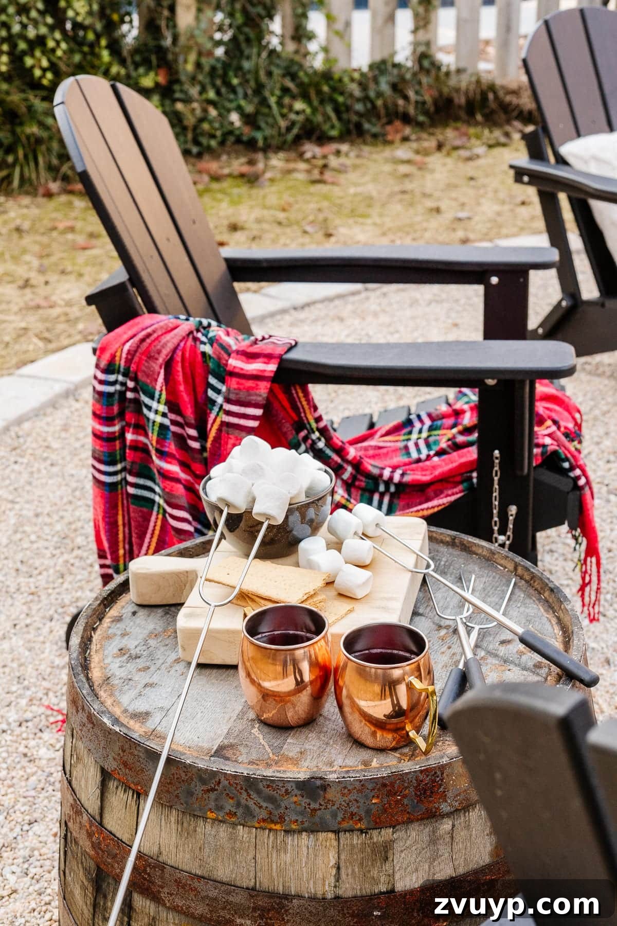 Weekend Wonder: DIY Pea Gravel Fire Pit 22 An Adirondack chair next to a barrel side table laden with s'mores ingredients, creating an inviting scene.