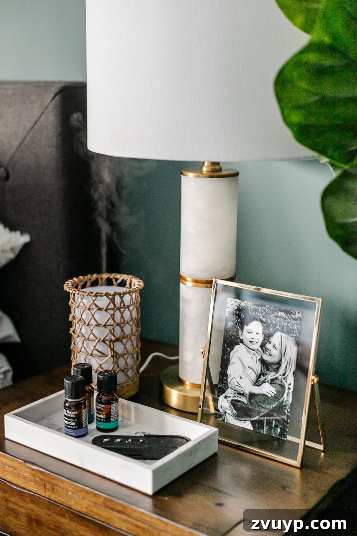Crafting a Spa Sanctuary: Bedroom Decor for Ultimate Serenity 14 Rattan essential oil diffuser, marble tray, and gold float frame on a nightstand