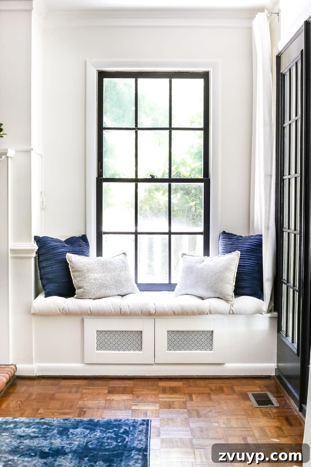 Smart Organization Solutions for a Clutter Free Home 24 A window seat with hidden compartments designed to conceal electronics beside a television, enhancing room aesthetics.