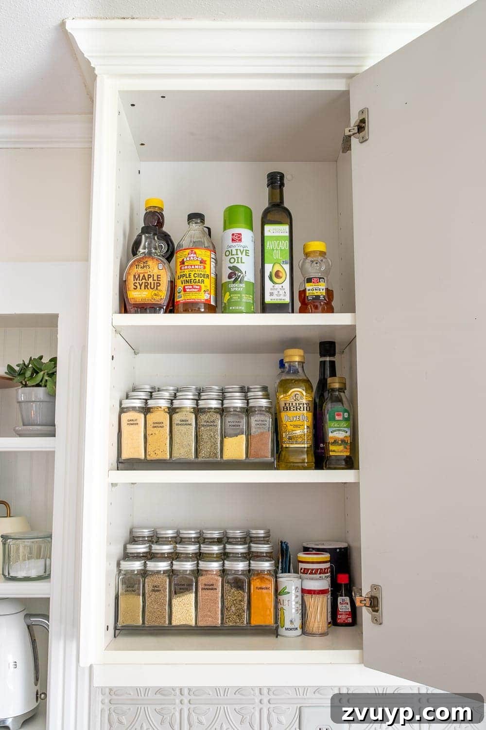 Smart Organization Solutions for a Clutter Free Home 6 A neatly organized spice cabinet featuring tiered shelves and matching spice bottles for easy visibility and access.