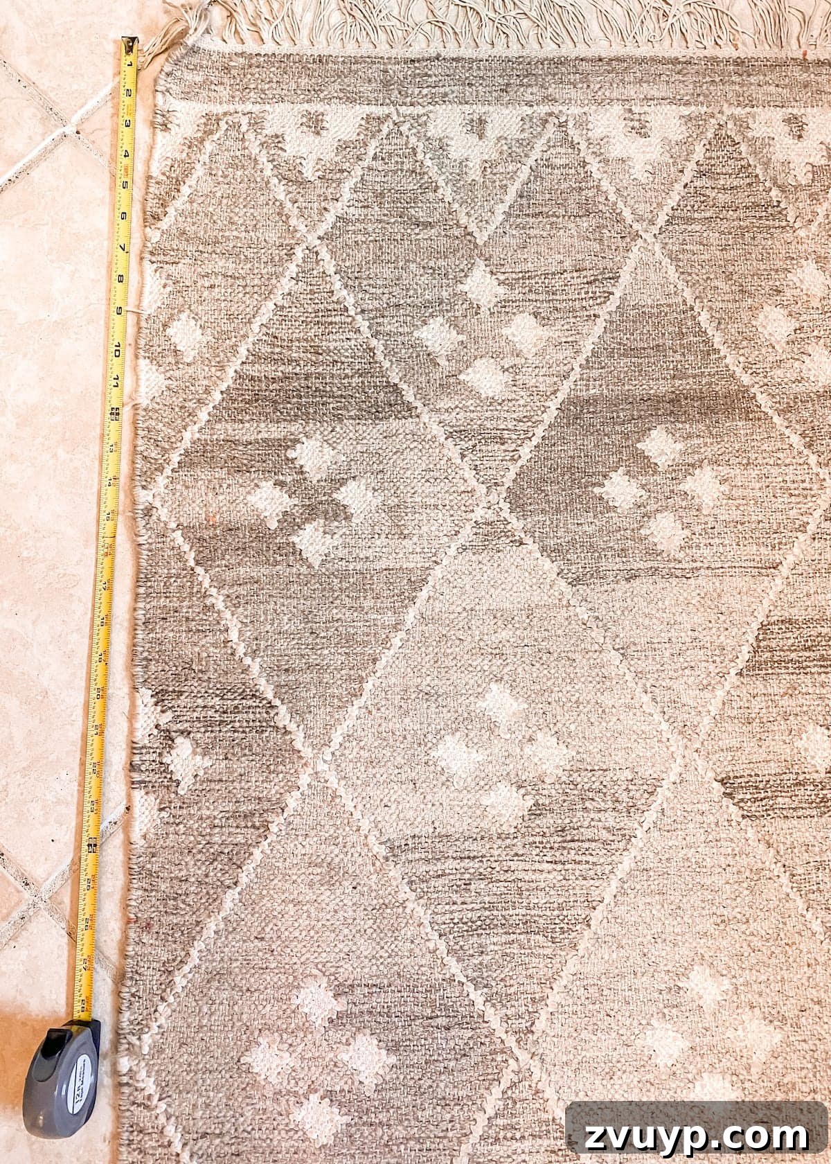 Close-up of fabric scissors cutting a marked flatweave rug.