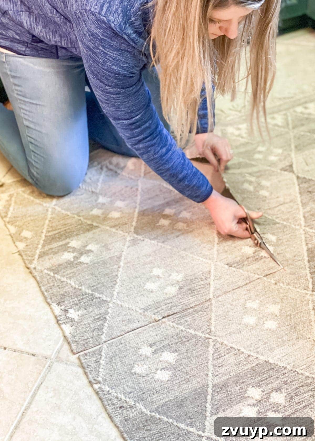 Applying hot glue to the back of a cut rug piece before attaching to the backer board.