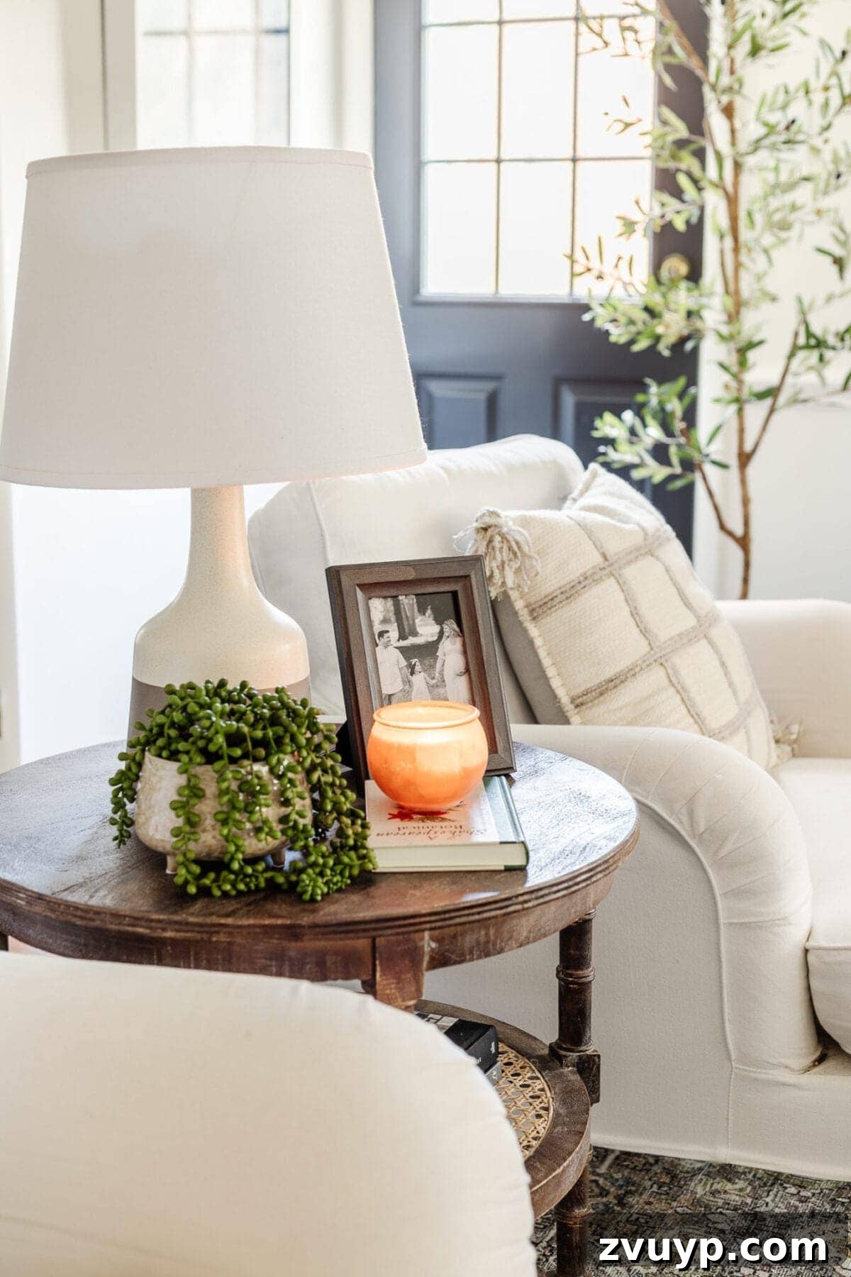 Seasonal Snuggle Spot My Favorite Winter Decor 7 Elegant winter decor on an end table with a potted plant and books, enhancing a neutral living space.