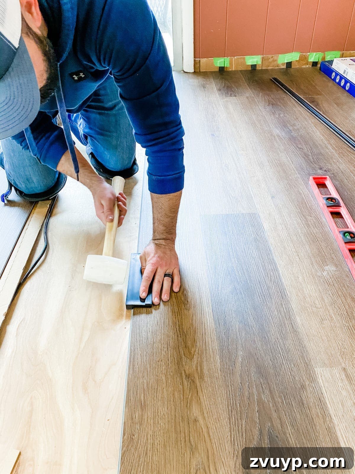 How to install luxury vinyl plank flooring, using a tapping block and rubber mallet