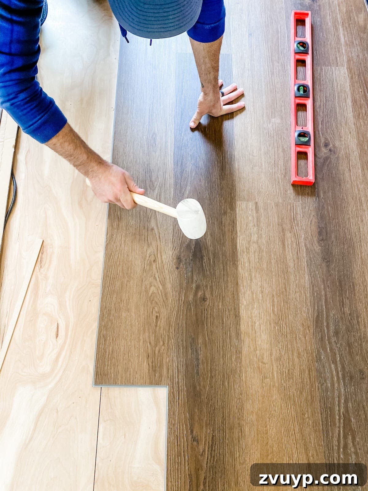 How to install luxury vinyl plank flooring, tapping seams with a rubber mallet