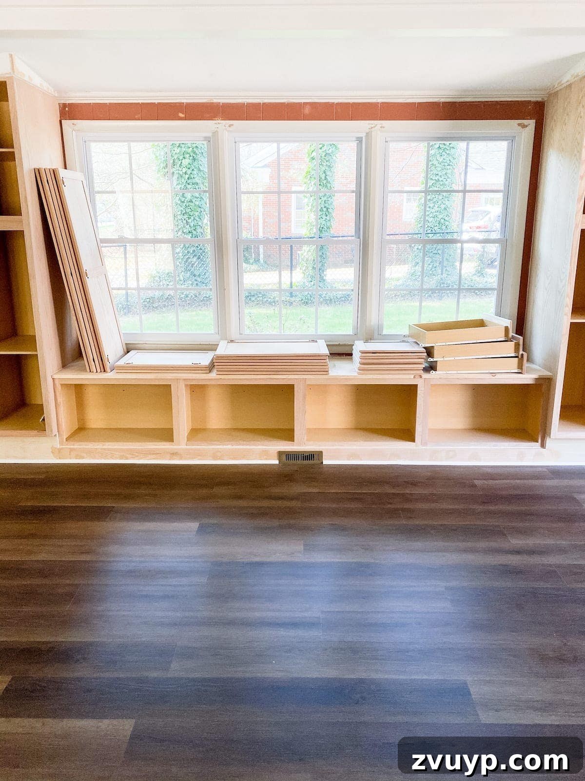 Luxury vinyl plank flooring with DIY built-in cabinets and window seat completed