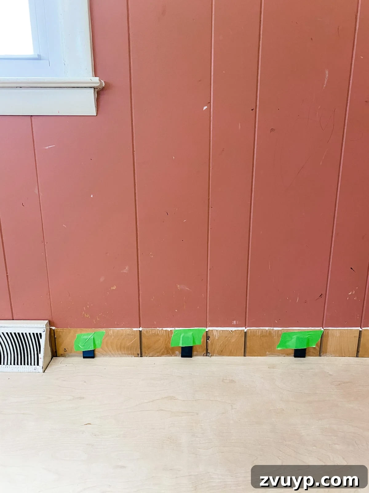 expansion spacers being placed around the room's perimeter for LVP flooring installation