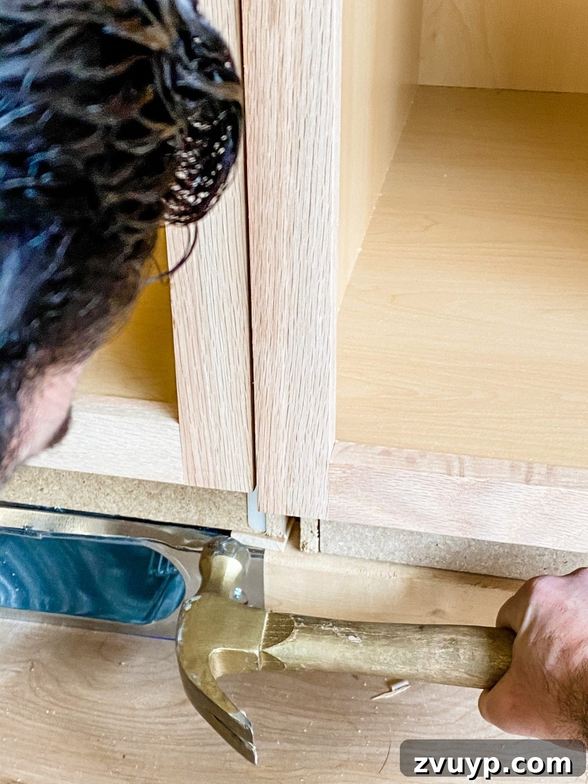 DIY Custom Built-In Storage and Window Nook 13 Wood shims being used to level a stock kitchen cabinet on the built-in base