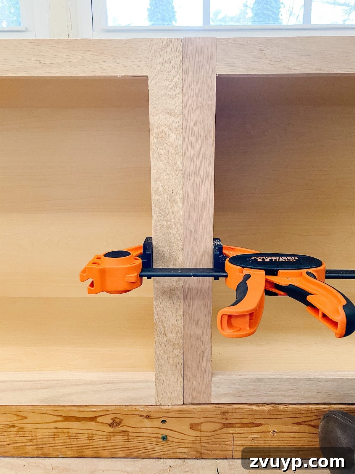 DIY Custom Built-In Storage and Window Nook 15 Clamps holding two stock kitchen cabinet frames together to ensure a flush alignment